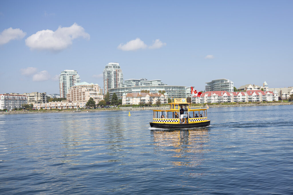un bateau taxi passe devant nous pour arriver au petit port de victoria. c'est une belle journée avec un ciel bleu