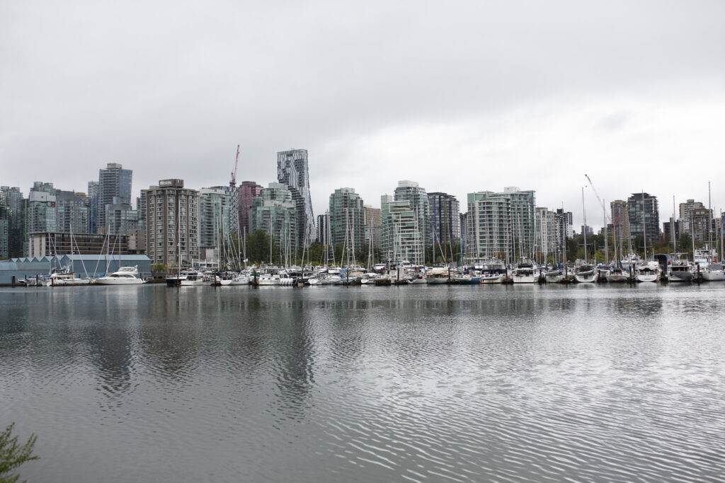 dans une atmosphère pluvieuse, le prt de vancouver s'étend devant nous avec ses bâteaux et ses grattes ciel