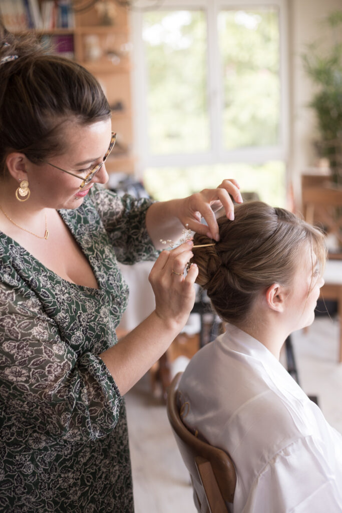 La future mariée en train de se faire coiffer lors de ses préparatifs chez ses parents