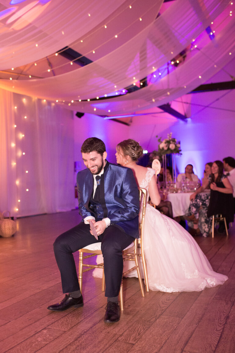 les mariés lors de la soirée, faisant un jeux assis sur une chaise